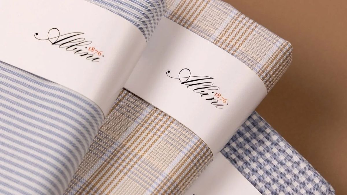Rolled Albini shirtings in blue stripe, tan check and grey gingham, each banded with the house label