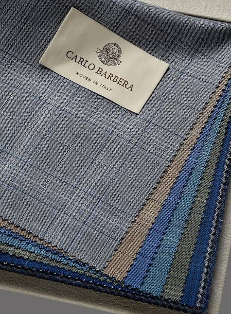A fan of Carlo Barbera suiting swatches in greys, blues and neutrals under the house label