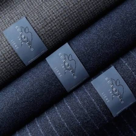 Three folds of navy and grey Guabello suiting with the mill tickets attached