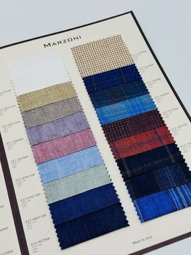An open Marzoni swatch book showing blues, neutrals and pastel shirtings