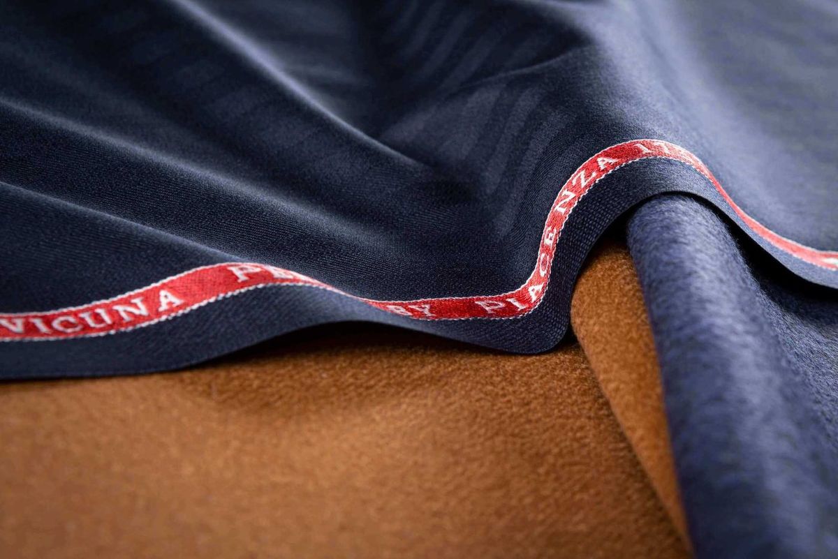Navy and tan Fratelli Piacenza vicuna cloth folded to show the selvedge