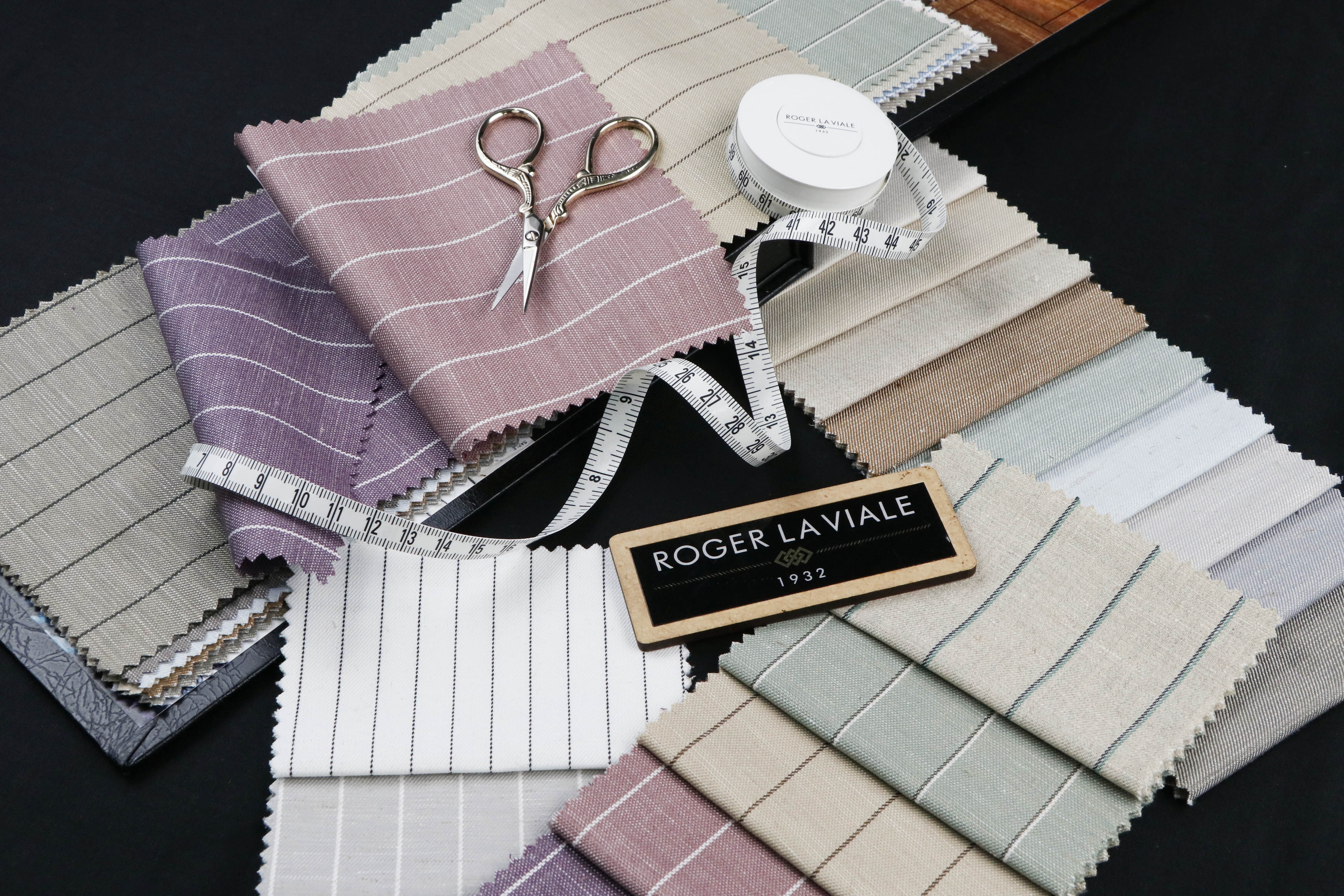 Roger La Viale striped shirting swatches fanned out with tailoring shears and a tape